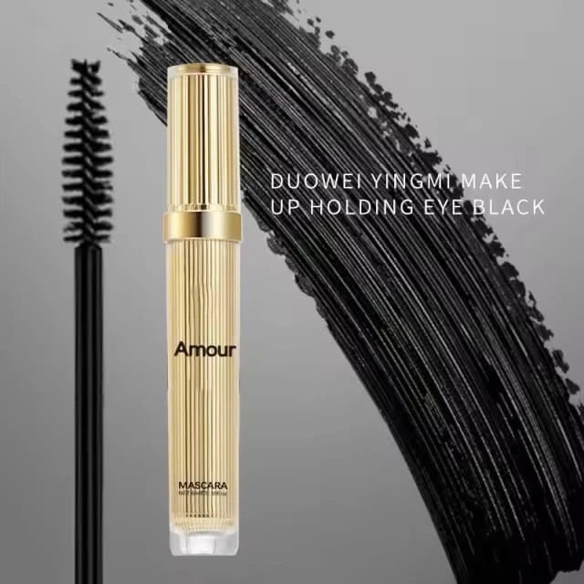 Mascara with gold casing and black lashes on a gray background