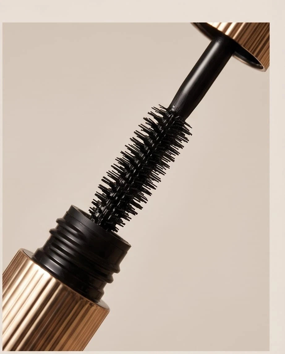 Close-up of a mascara wand with a beige background