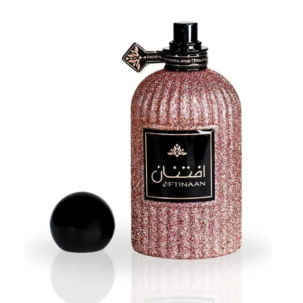Perfume bottle with glittery design and black cap on a white background