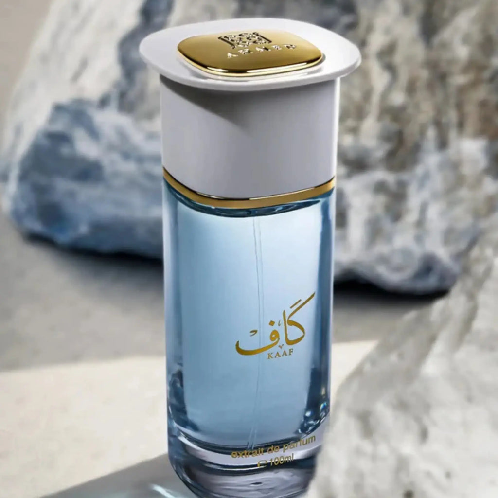 Perfume bottle with gold cap and Arabic text on a neutral background