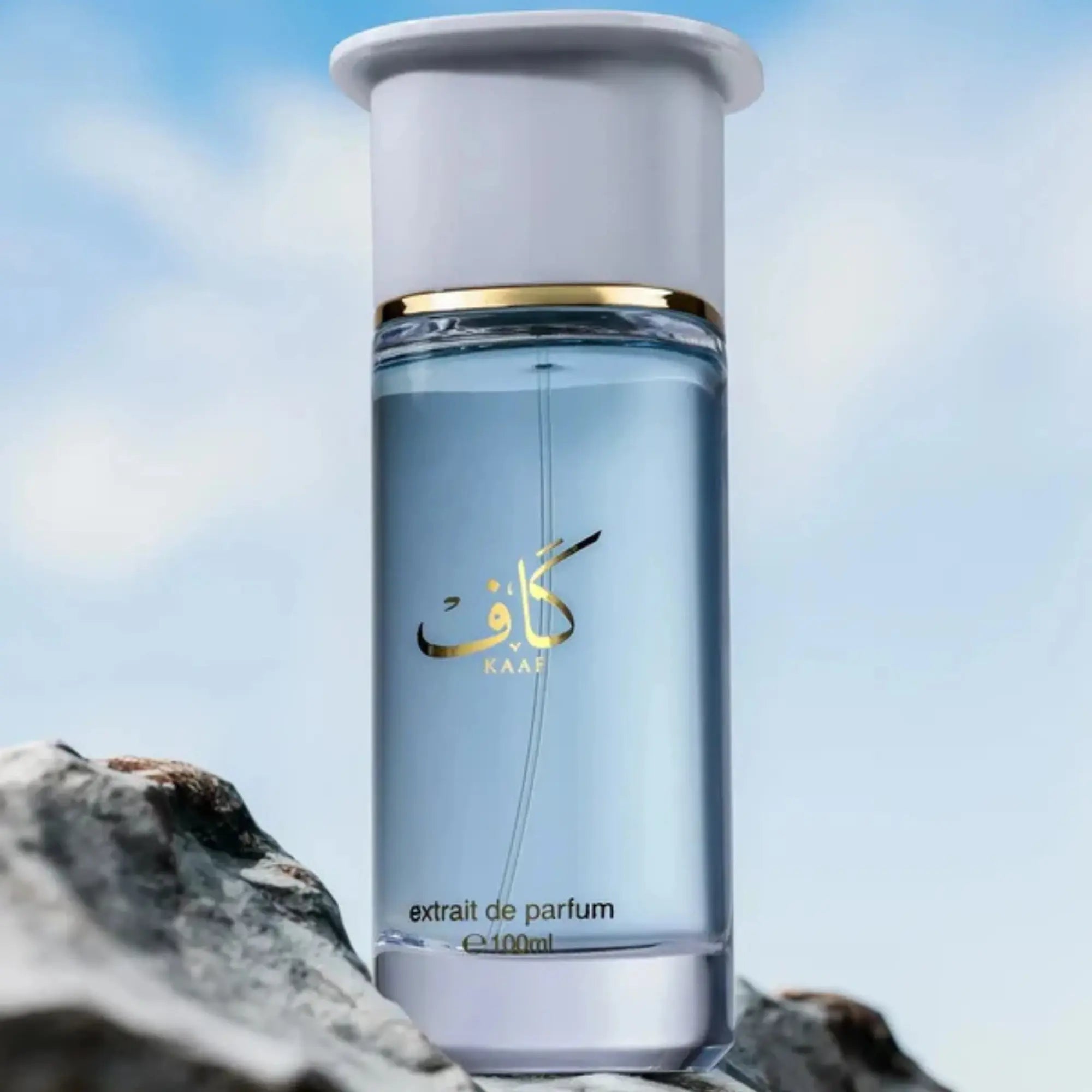 Perfume bottle with a gold cap on a rock with a blurred sky background