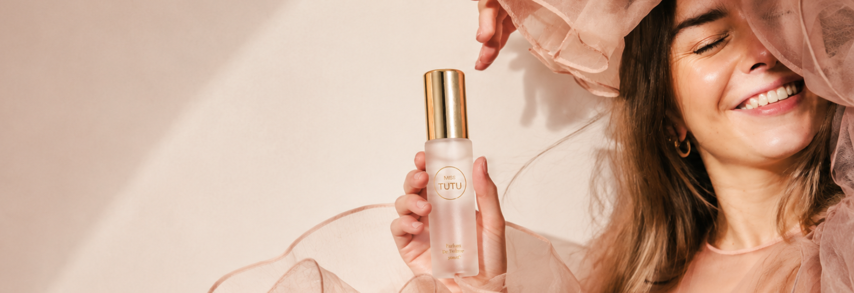 Woman holding a skincare bottle with a soft, blurred background
