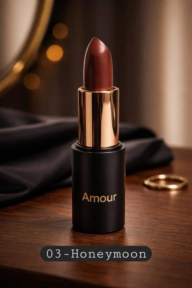 Lipstick with gold cap and black body labeled 'Amour' on a wooden surface.