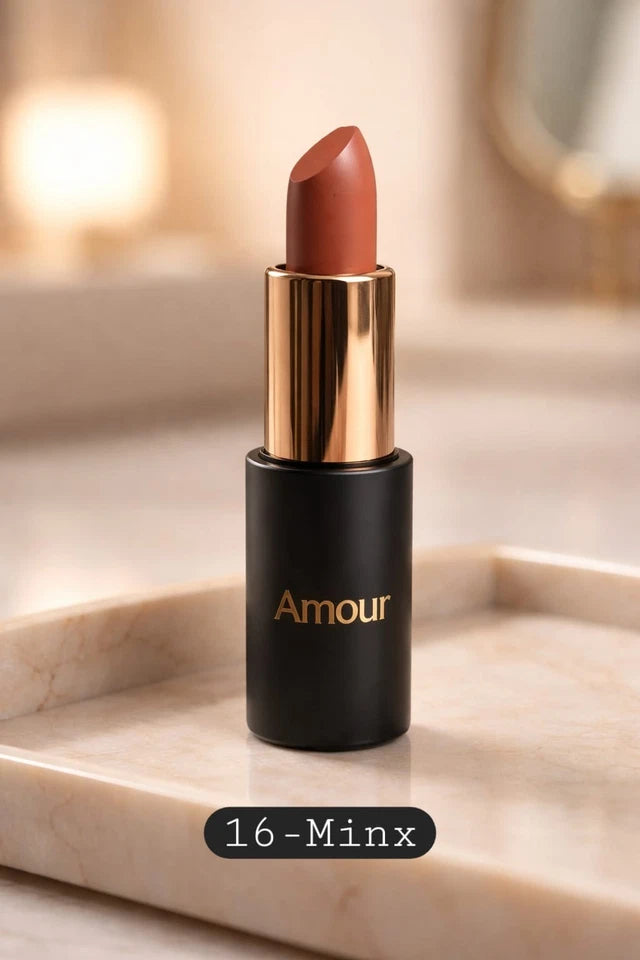 Lipstick with gold cap and black body labeled 'Amour' on a marble surface.