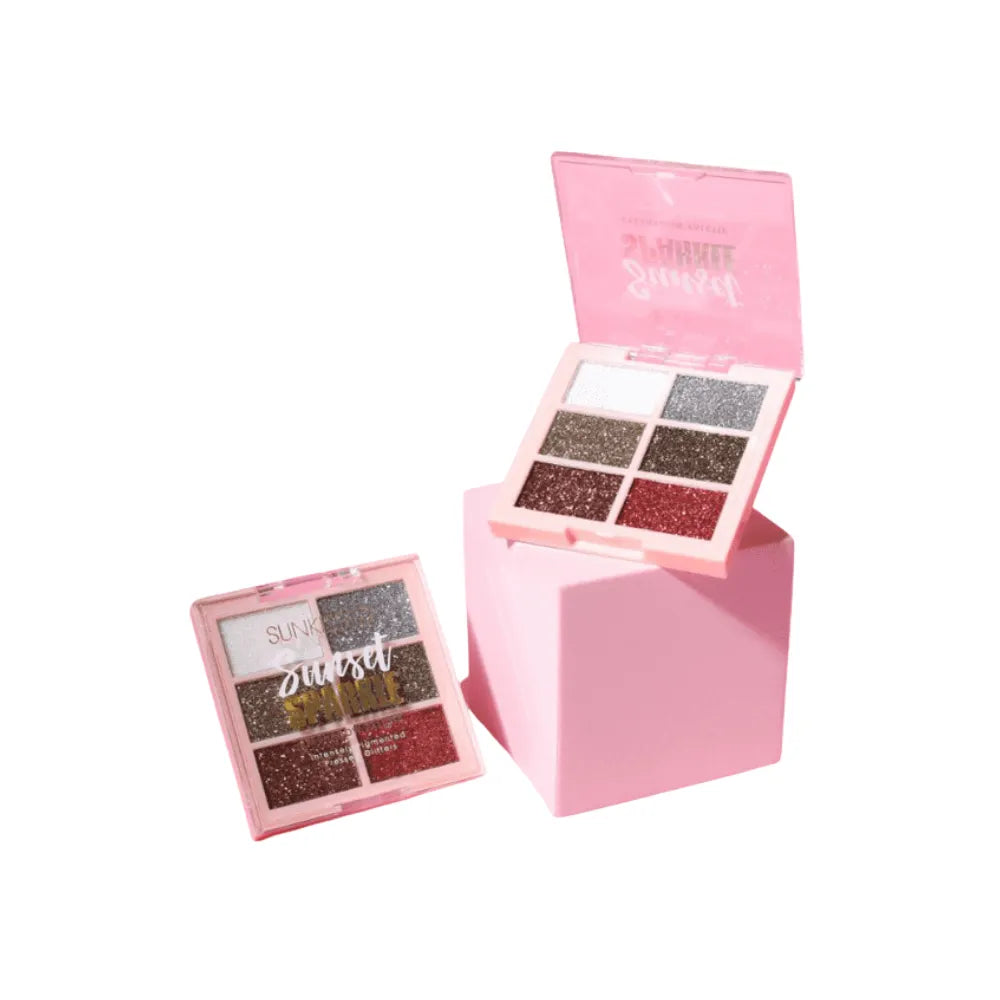 Makeup palette with glittery shades in a pink case on a white background