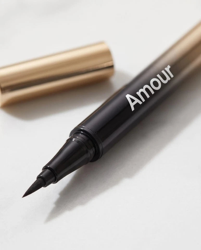 Two 'Amour' branded eyeliner pens on a marble surface